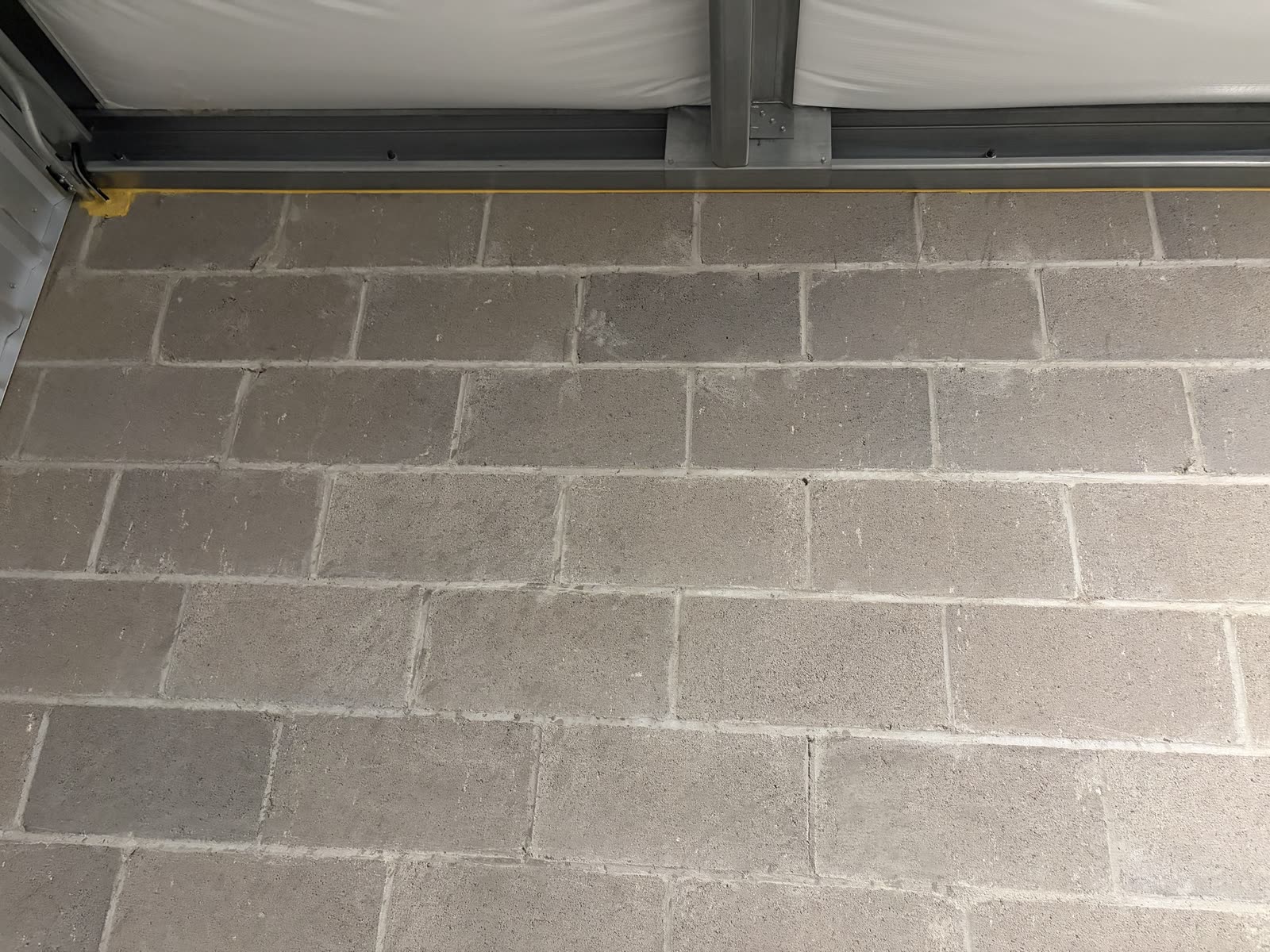 Fire-rated caulk sealing the top-of-wall joint where a CMU fire barrier wall meets the deck