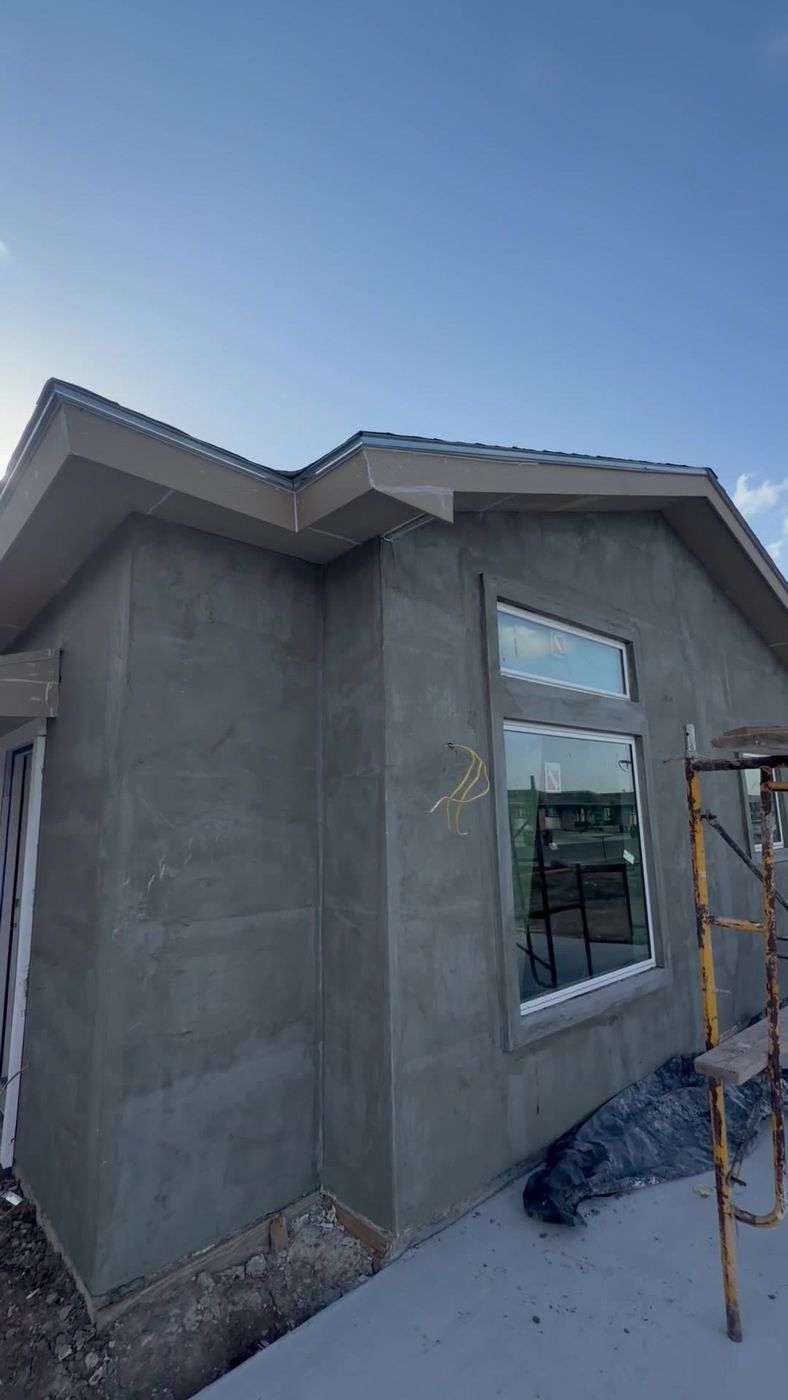 Exterior window and roofline sealing on a stucco home under construction